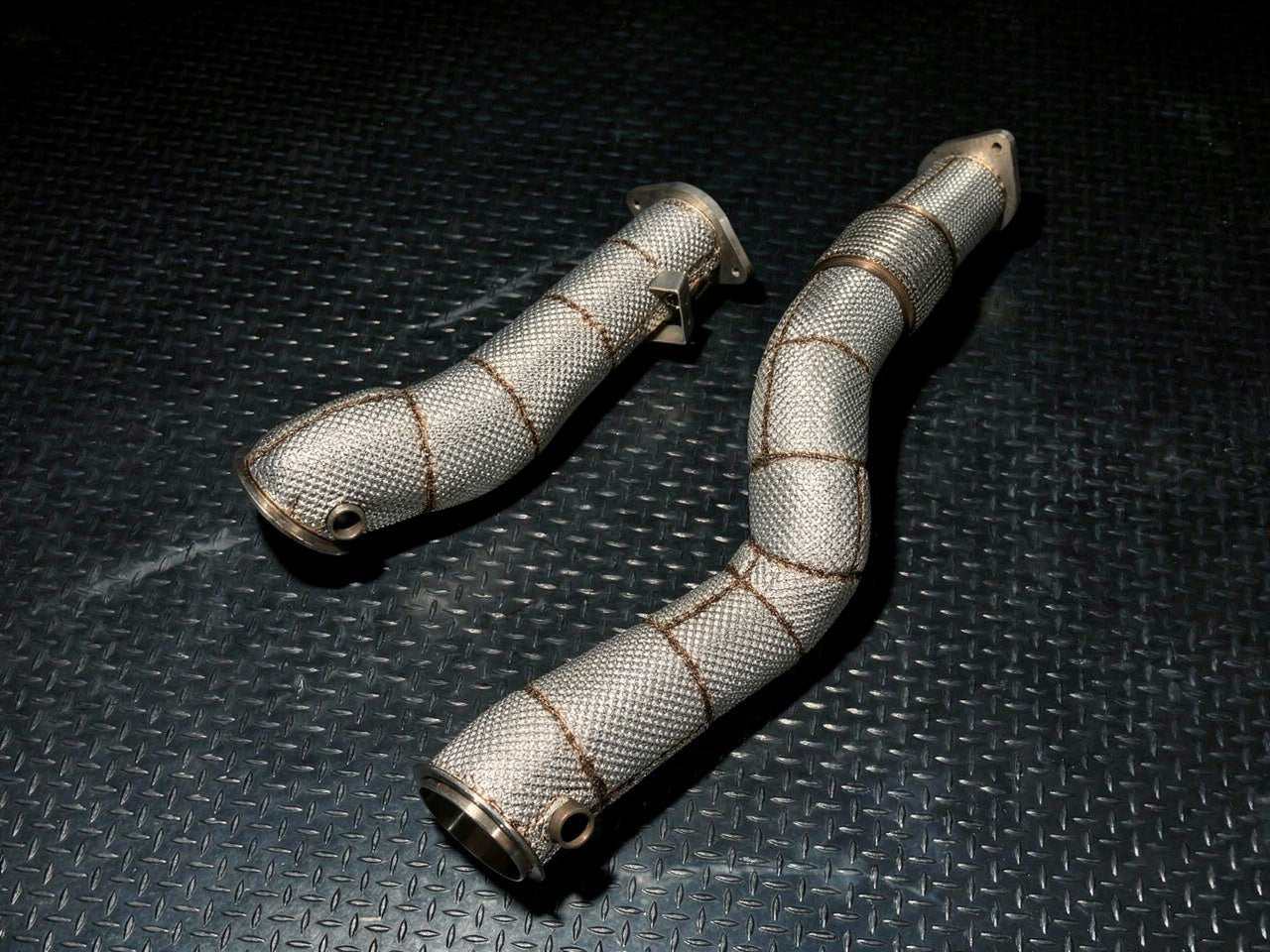 Pair of heat-wrapped S58 downpipes on shop diamond plate