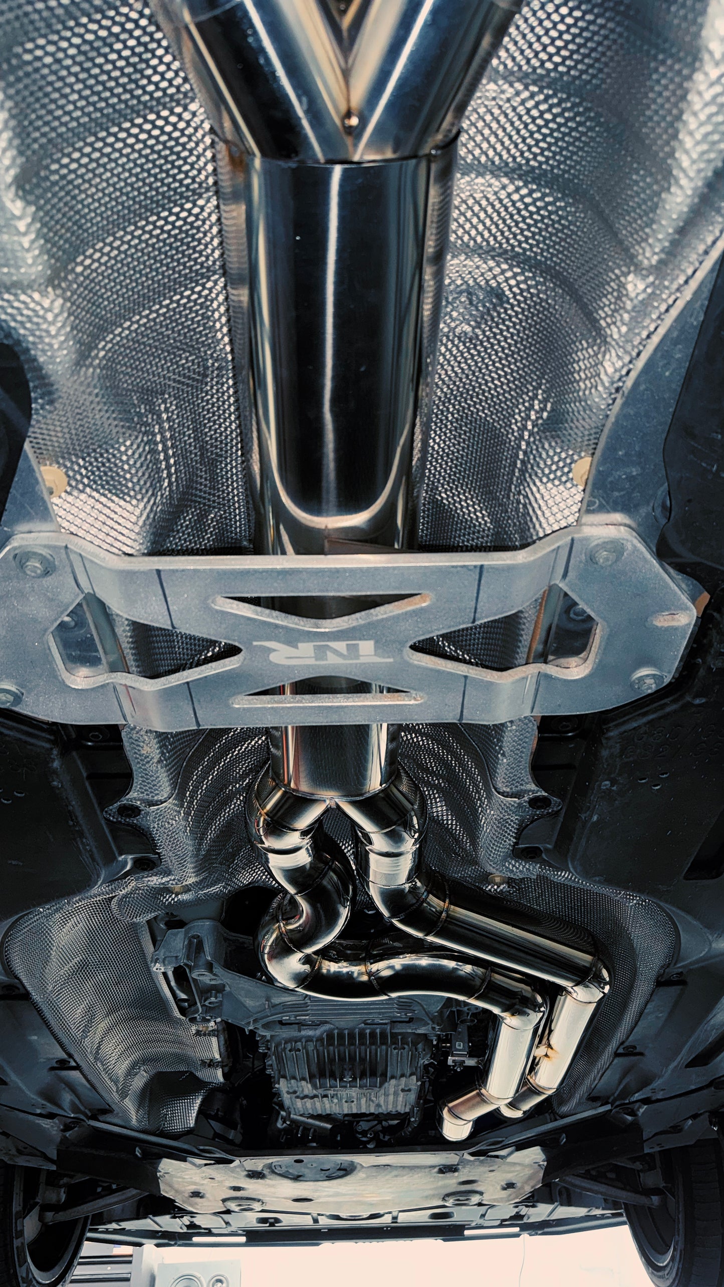 MACH-1 mid-section installed on a BMW G8X, viewed from below on the lift
