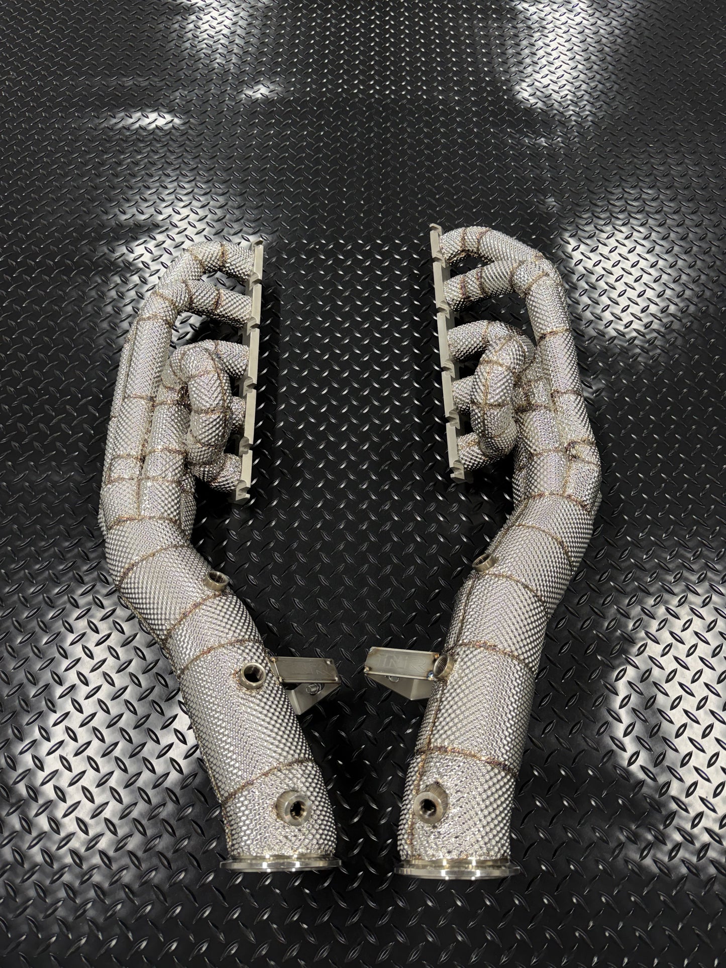 Pair of heat-wrapped V10 long-tube headers standing on diamond plate