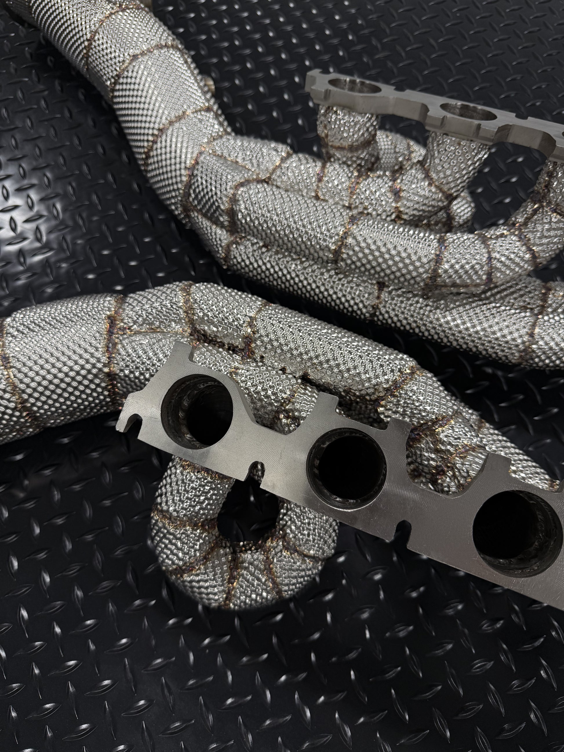 V10 header flange and heat-wrapped primaries, close-up